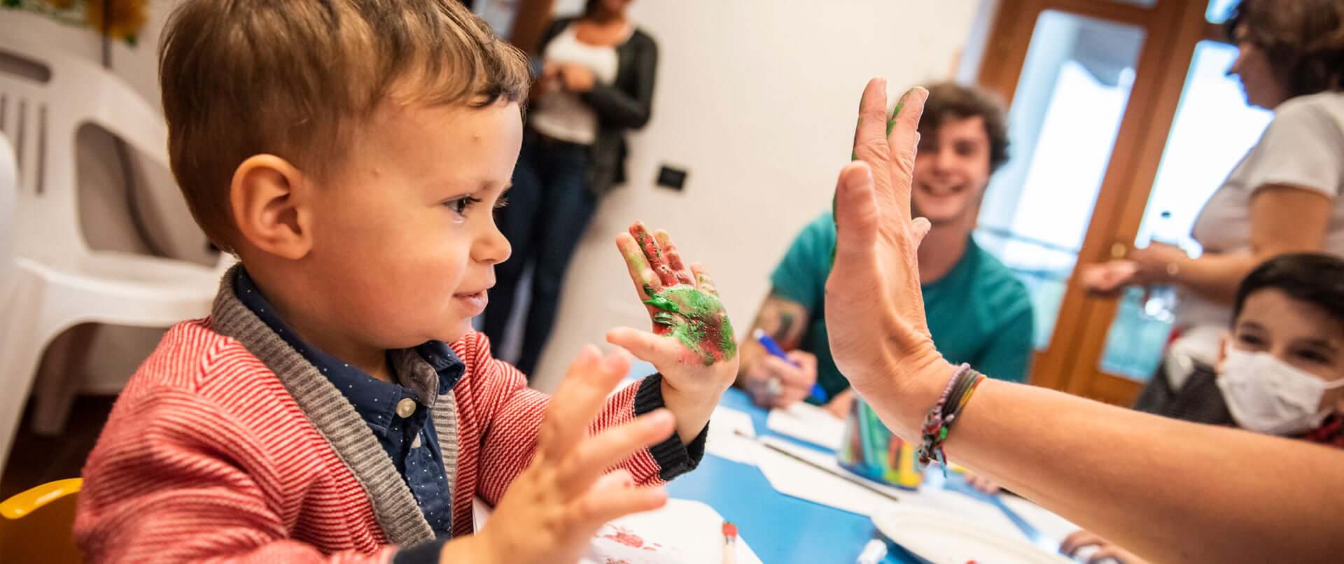 Bambino con mano sporca di colore