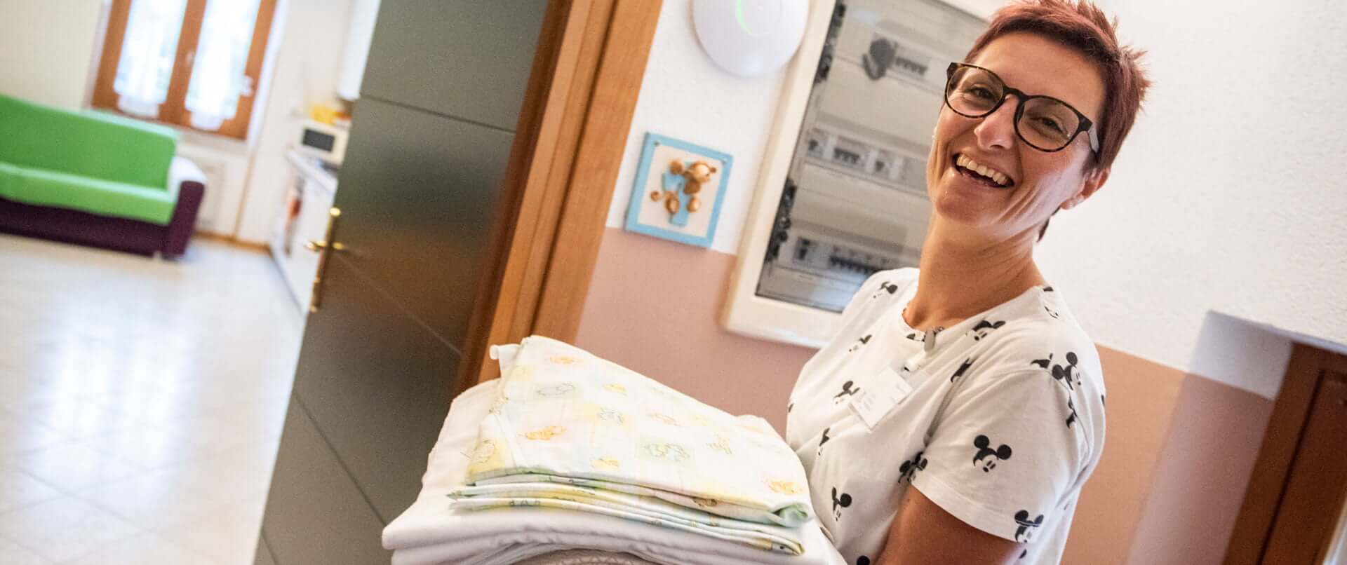 Donna sorridente con lenzuola pulite