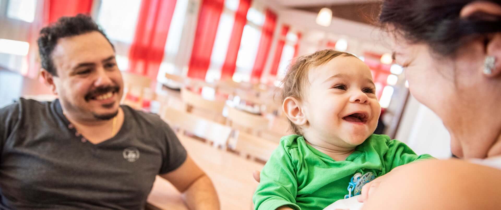 Bambino sorridente tra le braccia della mamma