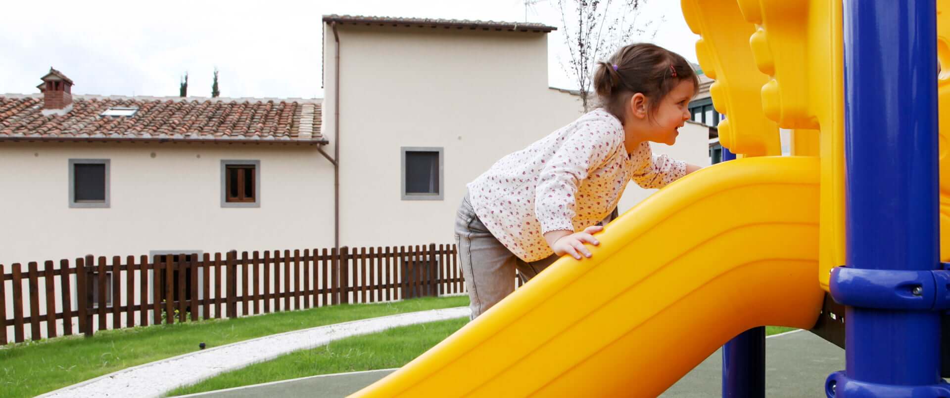 Bambina che gioca sullo scivolo